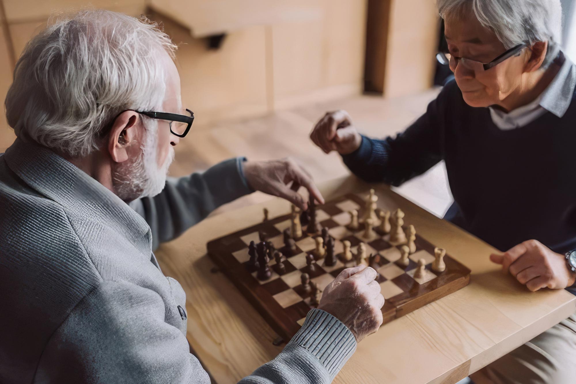 Two older men concentrate over a game of chess