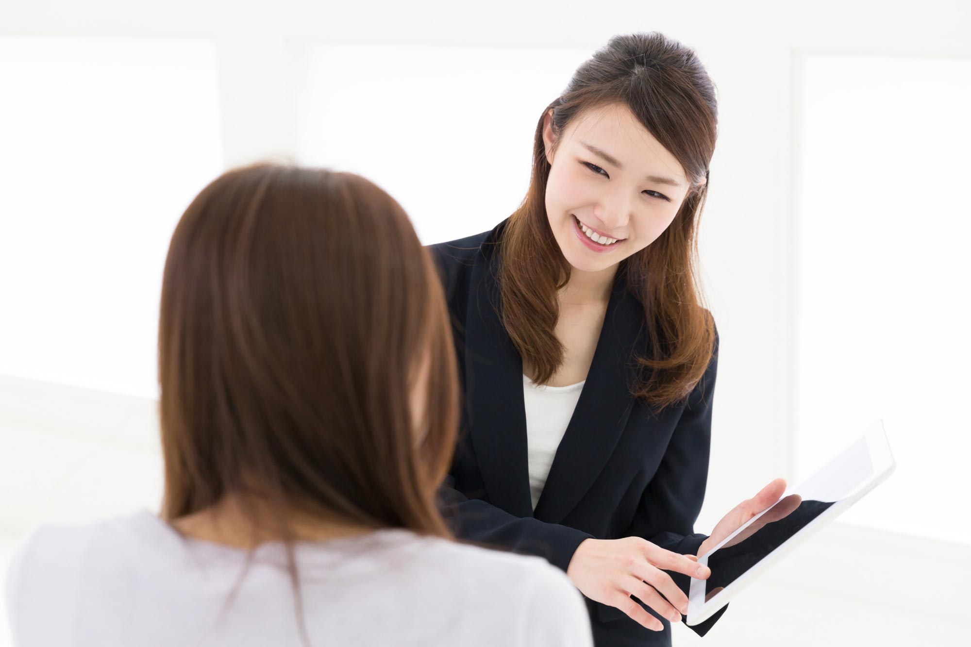 A MyDNA consultant smiles and shows a client a plan on a tablet